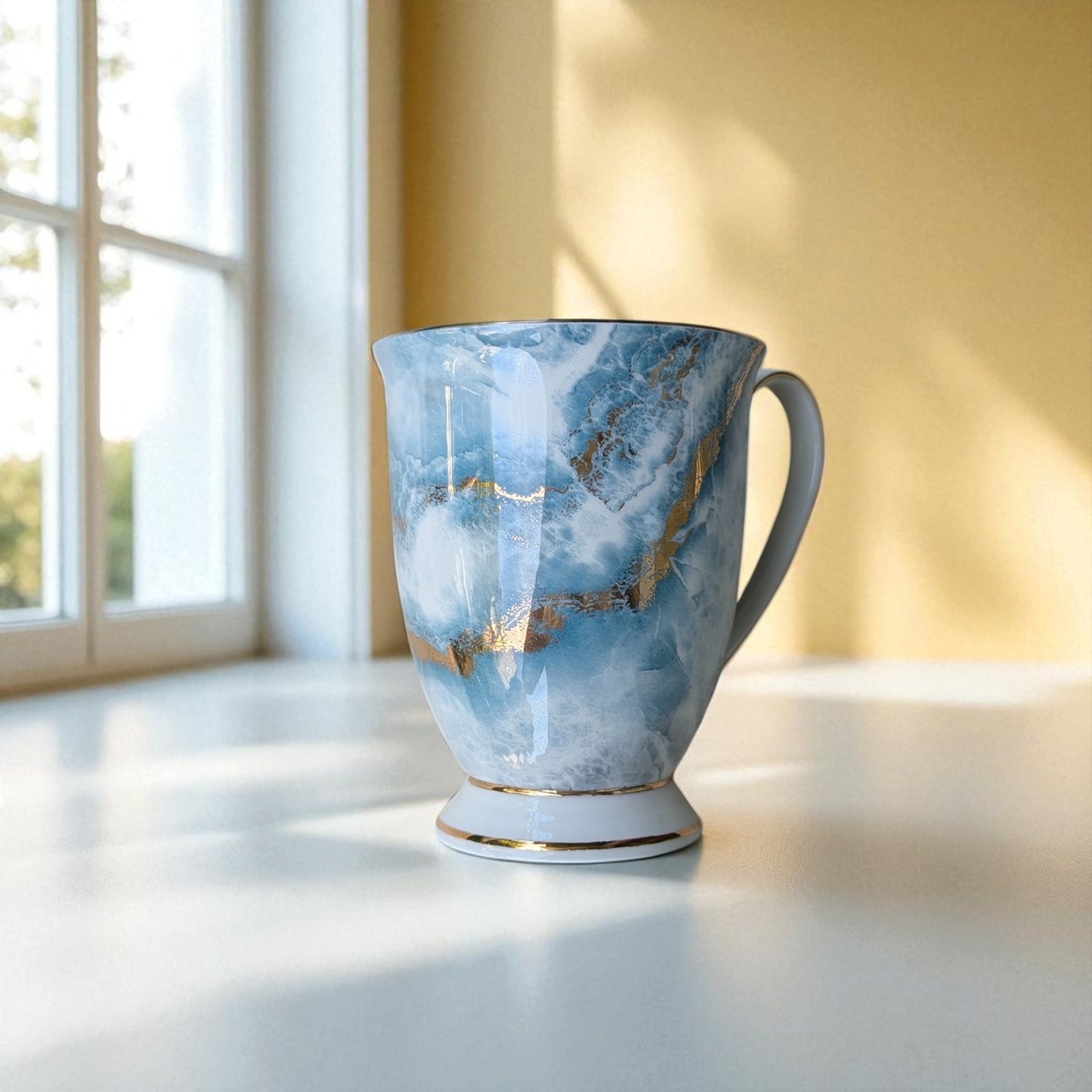 English Garden Milk Mug Autumn Tides with blue and gold marbled design on white table near window