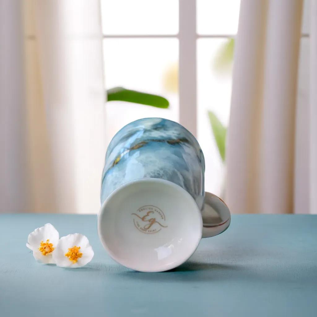 English Garden Milk Mug Autumn Tides with blue water-inspired design lying on its side next to white flowers