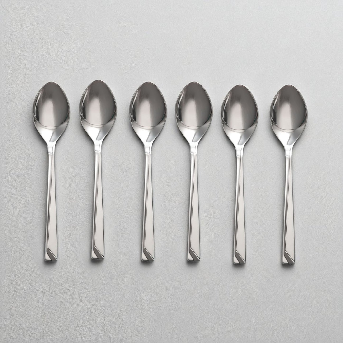 Set of six polished stainless steel Kishco Cutlery Olympus Baby Spoon arranged on a gray surface