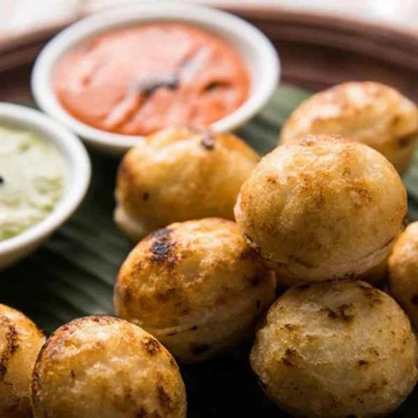 Golden brown appams cooked perfectly using the Meyer Cast Iron Appam Pan served with chutneys