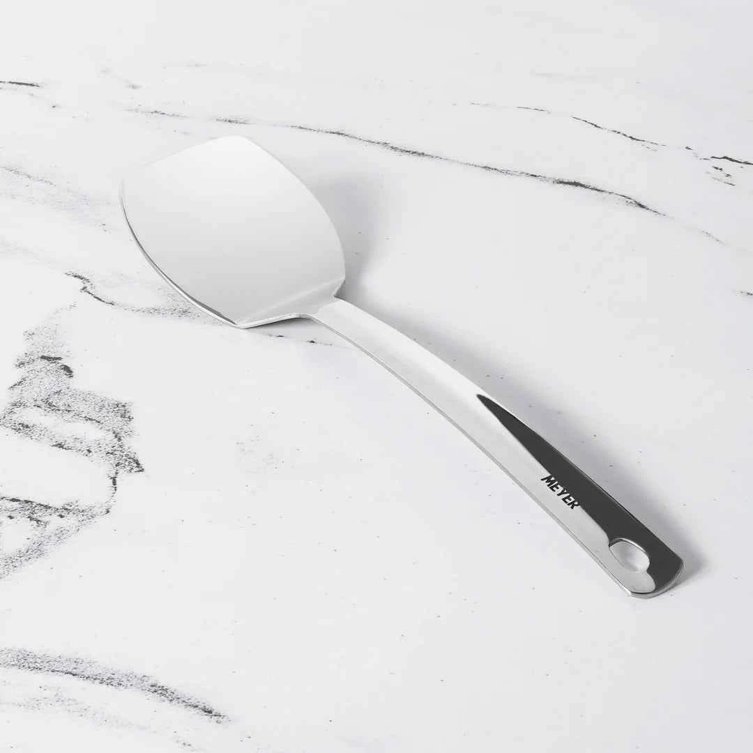 Meyer Stainless Steel Turner with ergonomic handle on white marble background