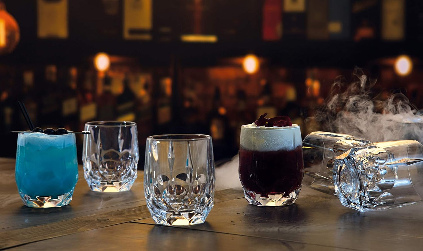 RCR Alkemist DOF crystal whiskey glasses displaying colorful cocktails in a lounge setting. Set of 6