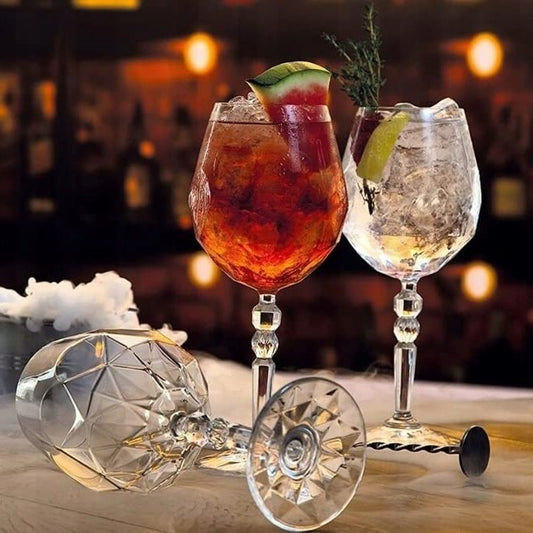 Set of RCR Alkemist Red Wine Glasses on a dark table, filled with wine, creating an elegant dining mood