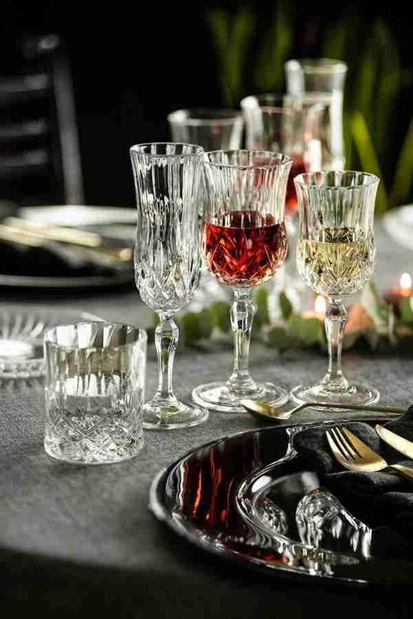 Set of 6 RCR Opera Red Wine Glasses on a table, some filled, showcasing elegant table setting for dining