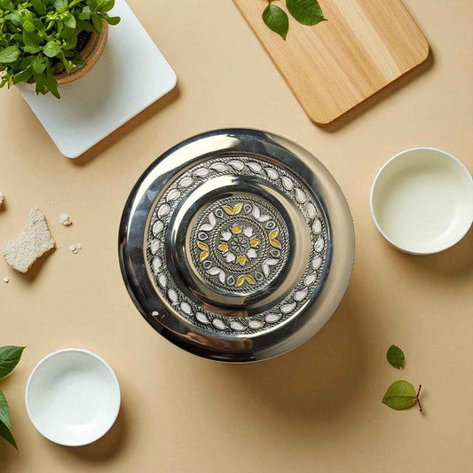 Mirror Antique Stainless Steel Half Dabba 2.5 litre with intricate floral design on lid placed on a beige surface