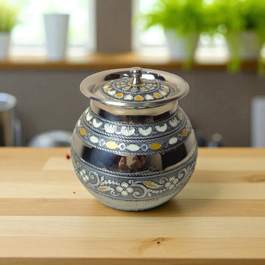 Antique Stainless Steel Lota with intricate floral and geometric designs on a wooden surface