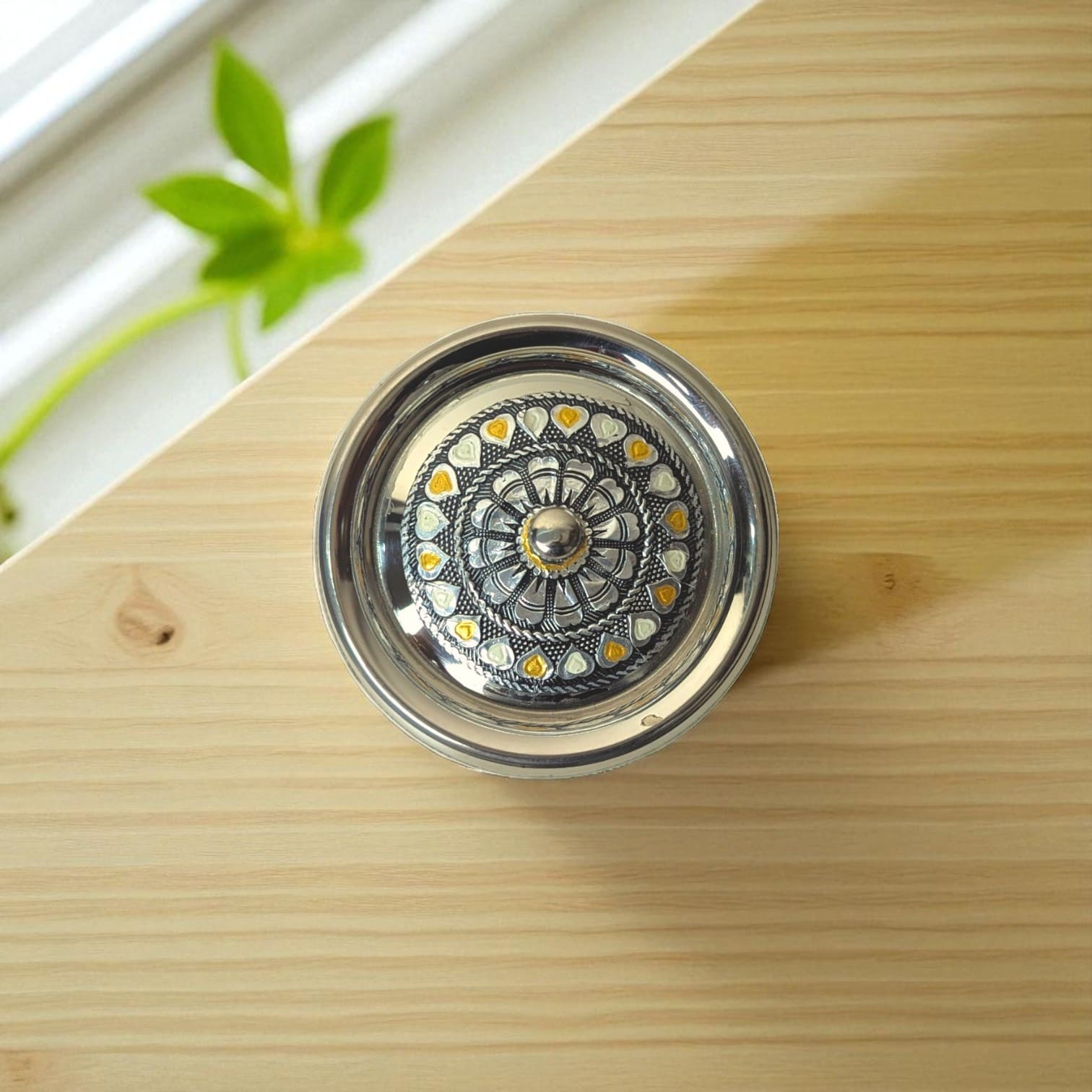 Antique Stainless Steel Lota with intricate floral and heart design from Mirror on wooden surface