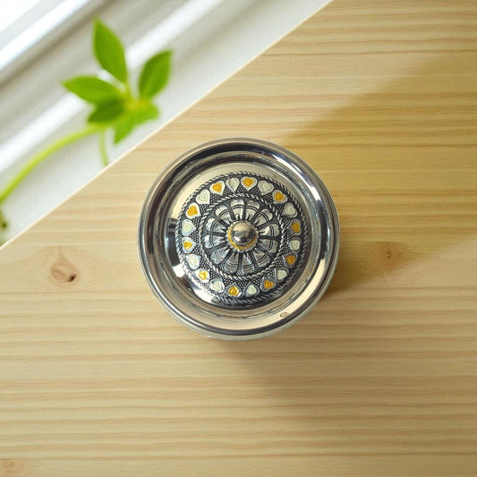 Antique Stainless Steel Lota with intricate floral and heart design from Mirror on wooden surface