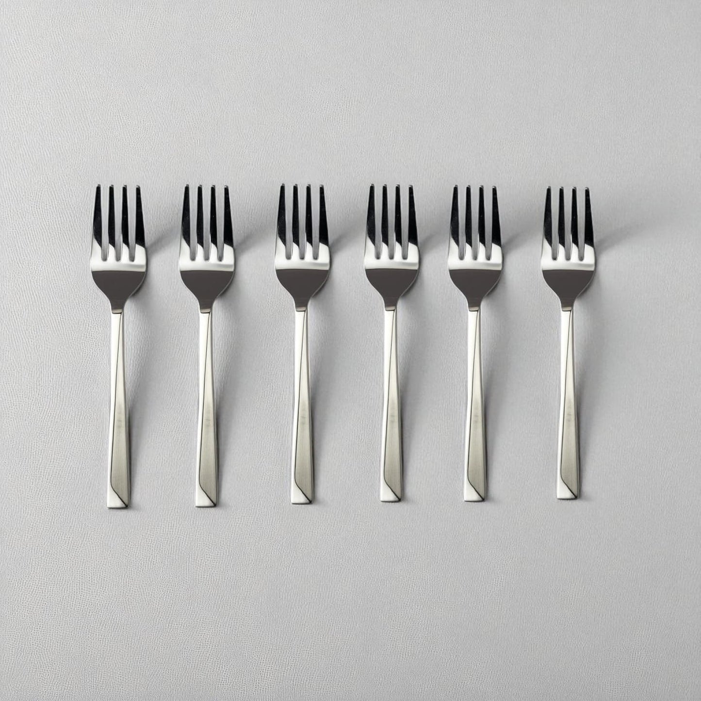 Set of six Kishco Cutlery Olympus Baby Forks with stainless steel polished finish on light background