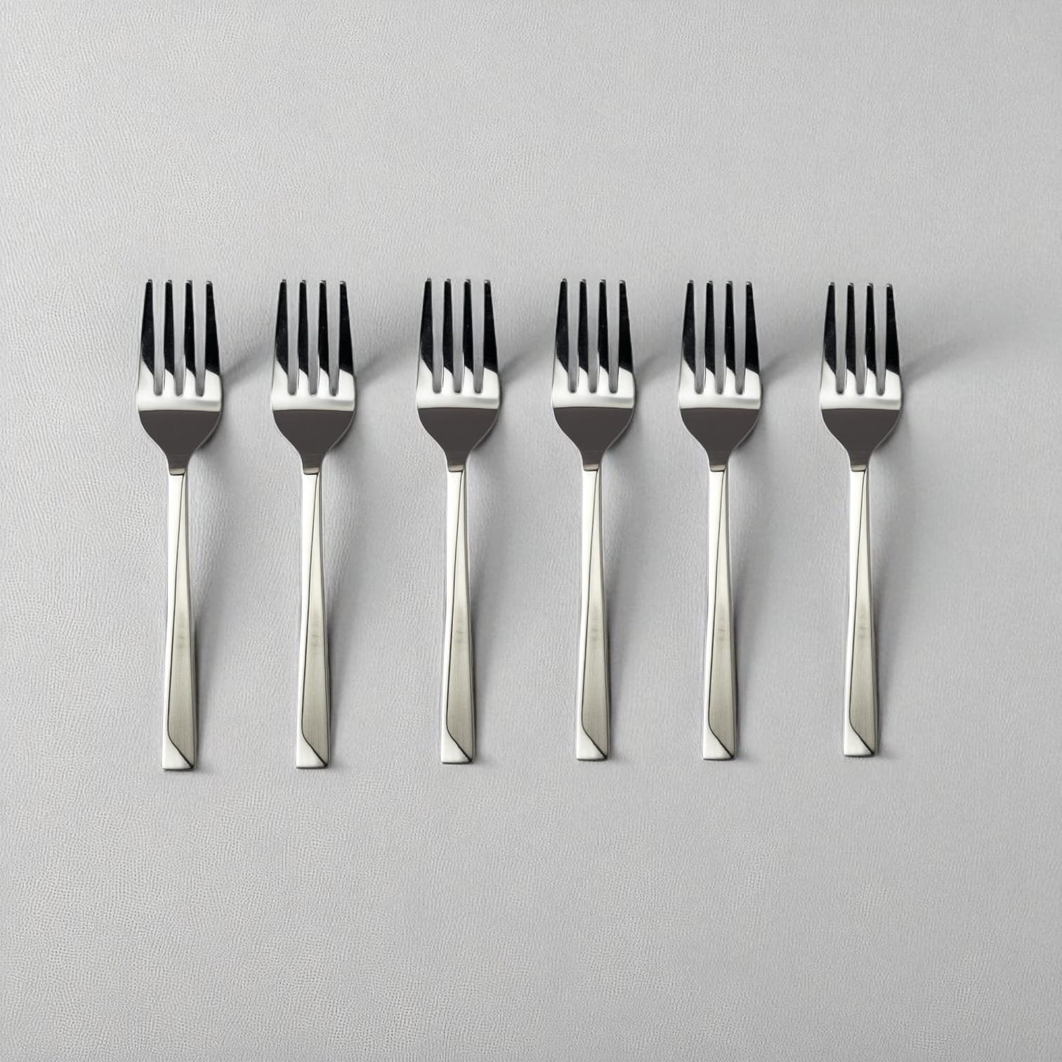 Set of six Kishco Cutlery Olympus Baby Forks with stainless steel polished finish on light background