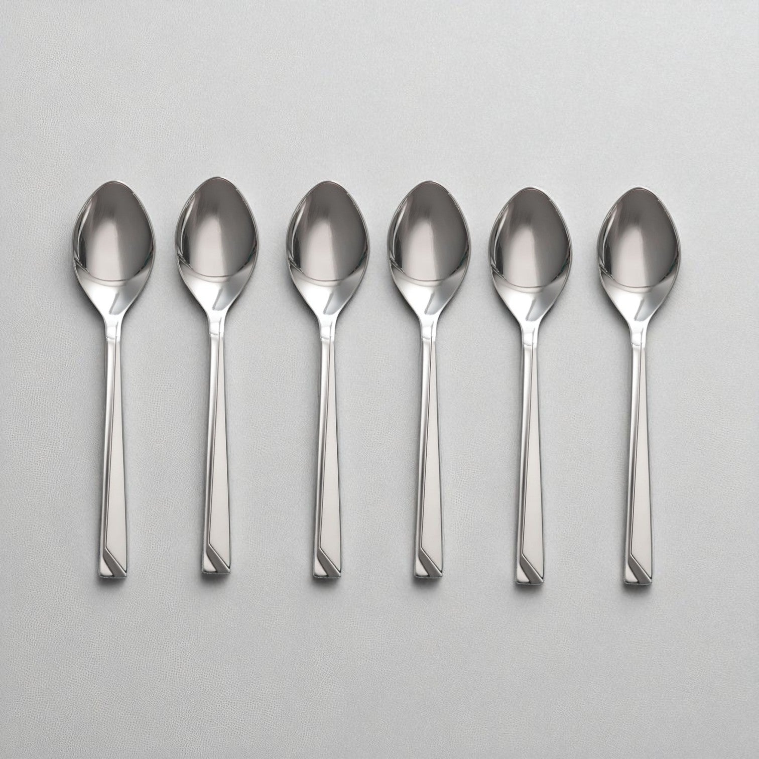 Set of six polished stainless steel Kishco Cutlery Olympus Baby Spoon arranged on a gray surface