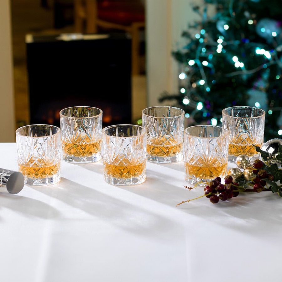 RCR Melodia DOF whiskey glasses with whiskey, styled in a festive lifestyle setting.