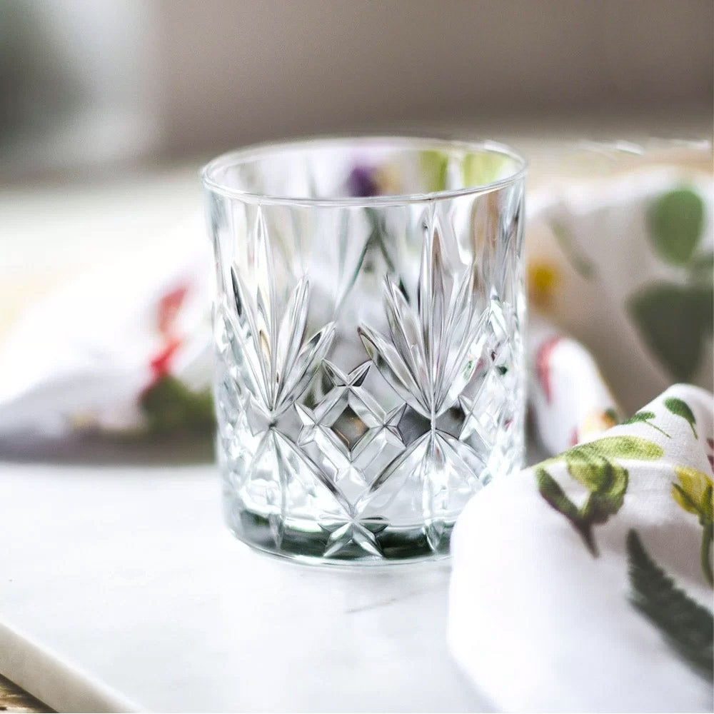 RCR Melodia DOF whiskey glasses styled on a white table setting.