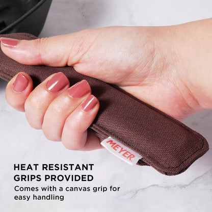 Hand holding heat resistant canvas grip for Meyer Cast Iron Grill Pan for safe handling