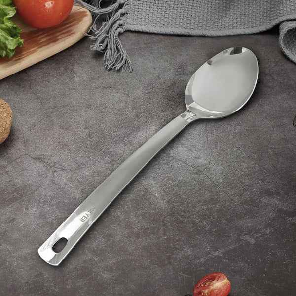 Meyer Stainless Steel Serving Spoon with polished finish on gray kitchen countertop