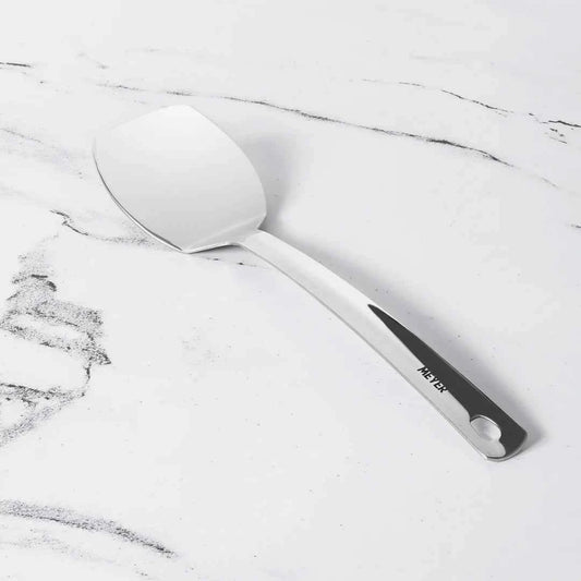 Meyer Stainless Steel Turner with ergonomic handle on white marble background
