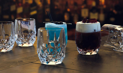 RCR Alkemist DOF crystal whiskey glasses filled with various drinks on a dark bar, ideal for entertaining