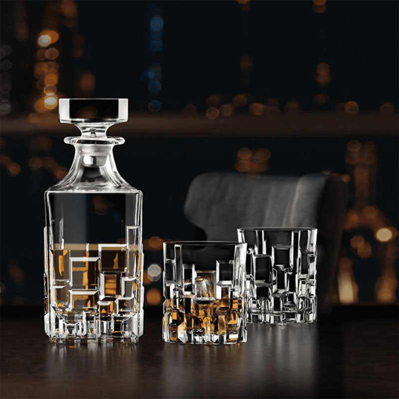 RCR Etna Whiskey Decanter Bottle with whiskey glasses on a dark lifestyle background
