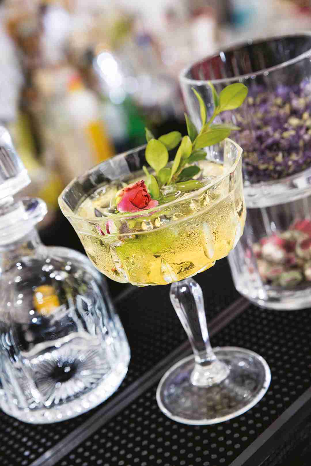 RCR Opera Champagne Goblet styled with a botanical cocktail garnished with a rose and mint