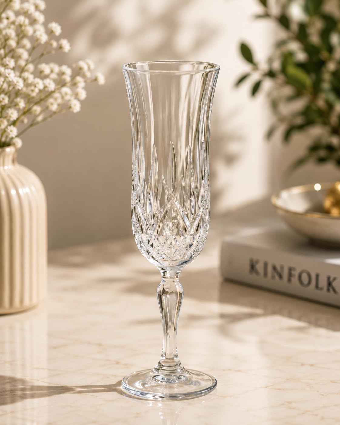 RCR Opera Flute Goblet styled on a marble countertop with flowers, lifestyle setting