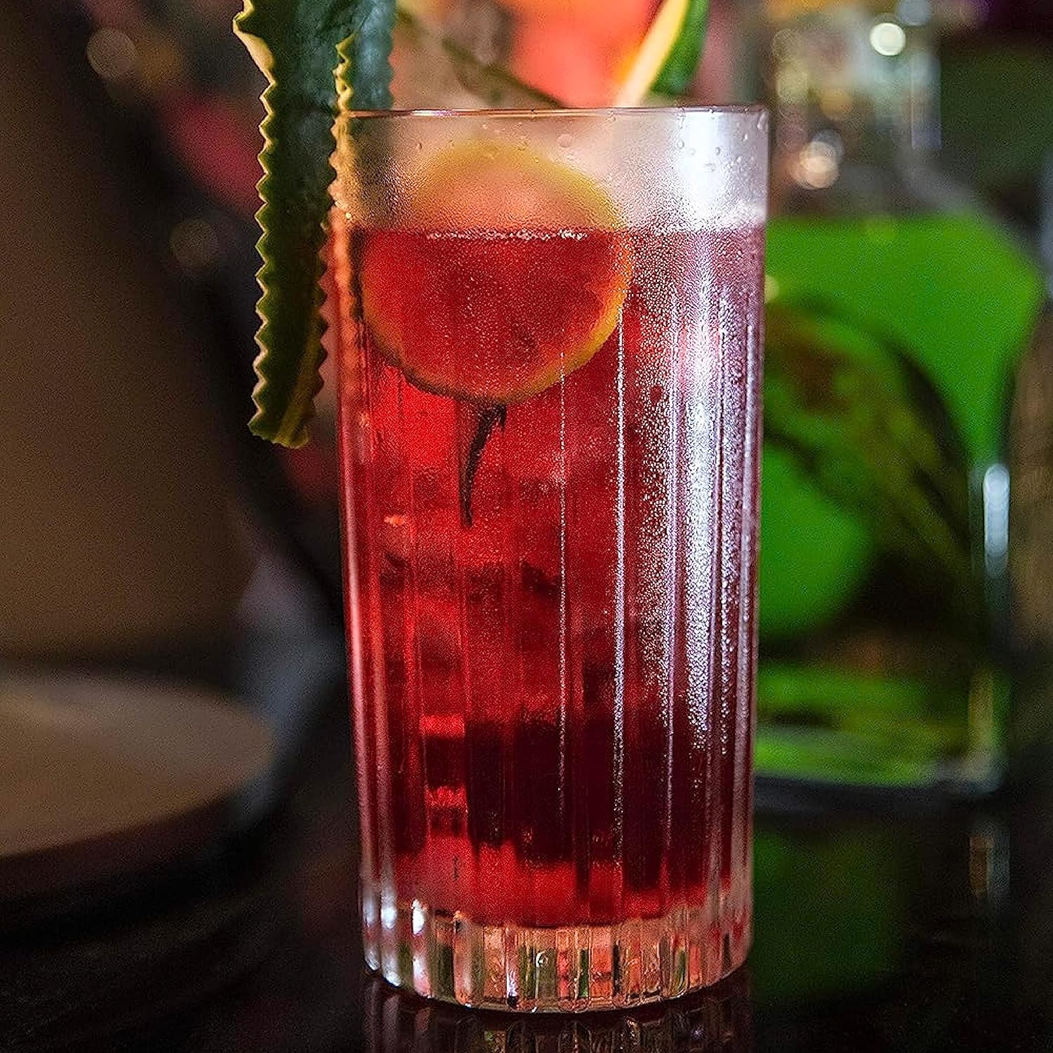 RCR Timeless cocktail glasses set showcasing a vibrant cocktail with garnish on a bar counter