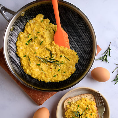 Stahl Artisan Hybrid Triply Fry Pan with Lid 24 cm cooking a fluffy omelette with herbs and eggs on the side